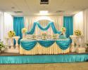 Beautiful, elegant and sophisticated wedding decor. Teal and white drapery enhance the table for the bride and groom.