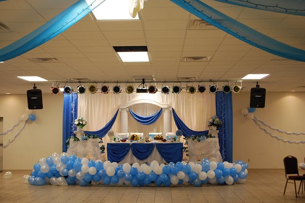 This beautiful bridal table features gorgeous white and blue drapery behind it, as well as on the table. Also, the ceiling features gorgeous draping too.