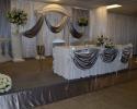 Bride and Groom Table with white and metallic drapery.