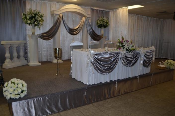 Bride and Groom Table with white and metallic drapery.