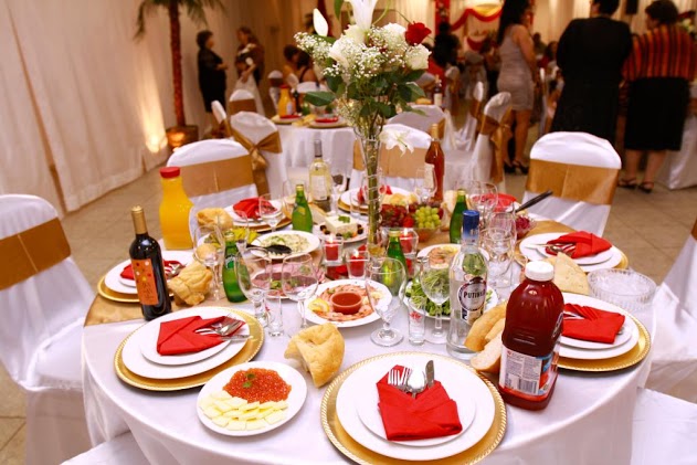 This reception table is all set and ready to go with the gold and white place settings, orange napkins and beautiful centerpiece.